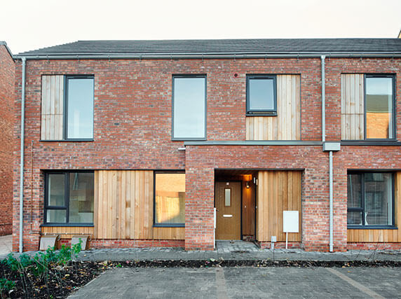 Rainmen installation - Zambelli galvanised steel rainwater drainage with aluminium pike capping on family home, Liverpool social housing project