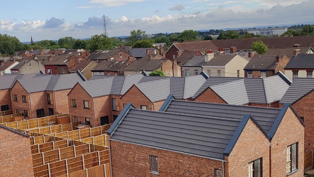 Aluminium pike cappings on the gable ends of new-build social housing at a 48-home brownfield development in Liverpool's Fairfield area, with Zambelli galvanised steel rainwater systems throughout